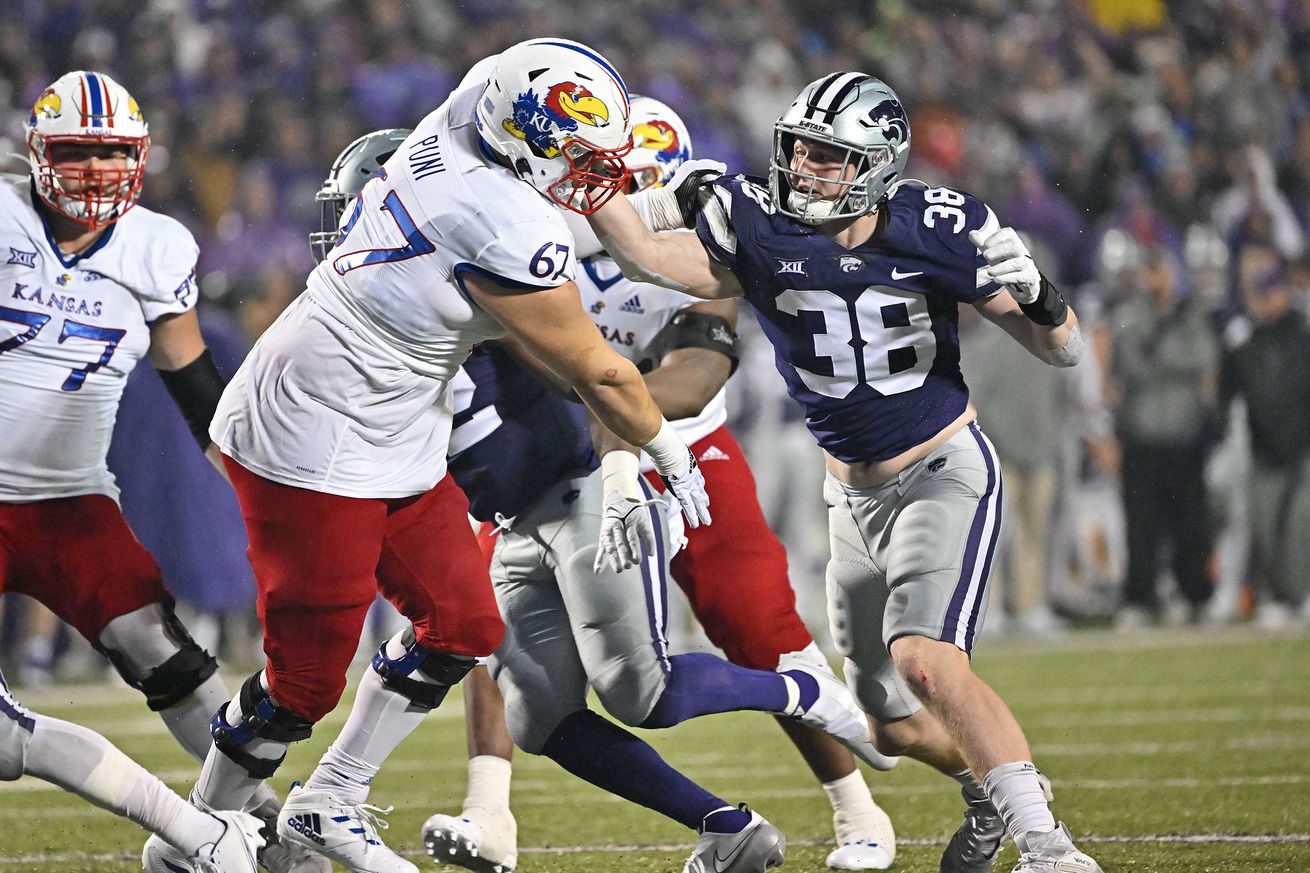 MANHATTAN, KS - NOVEMBER 26: Defensive end Brendan Mott #38 of the Kansas State Wildcats rushes against offensive lineman Dominick Puni #67 of the Kansas Jayhawks, during the second half against the at Bill Snyder Family Football Stadium on November 26, 2022 in Manhattan, Kansas.