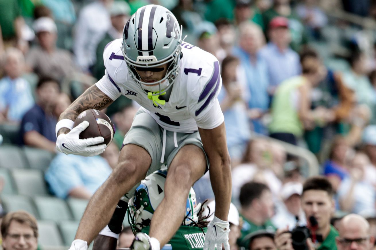 NEW ORLEANS, LOUISIANA - SEPTEMBER 7: Jayce Brown #1 of the Kansas State Wildcats leaps over Jack Tchienchou #29 of the Tulane Green Wave during the first half of a game at Yulman Stadium on September 7, 2024 in New Orleans, Louisiana.