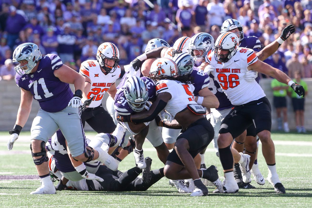 Sep 28, 2024; Manhattan, Kansas, USA; Kansas State Wildcats running back DJ Giddens (31) is tackled by Oklahoma State Cowboys safety Kendal Daniels (5) during the first quarter at Bill Snyder Family Football Stadium.