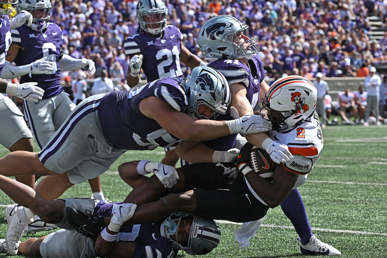  MANHATTAN, KS - SEPTEMBER 28: Cornerback Jacob Parrish #10, defensive tackle Damian Ilalio #56 and linebacker Austin Moore #41 of the Kansas State Wildcats tackle wide receiver Talyn Shettron #2 of the Oklahoma State Cowboys, in the second half at Bill Snyder Family Football Stadium on September 28, 2024 in Manhattan, Kansas.