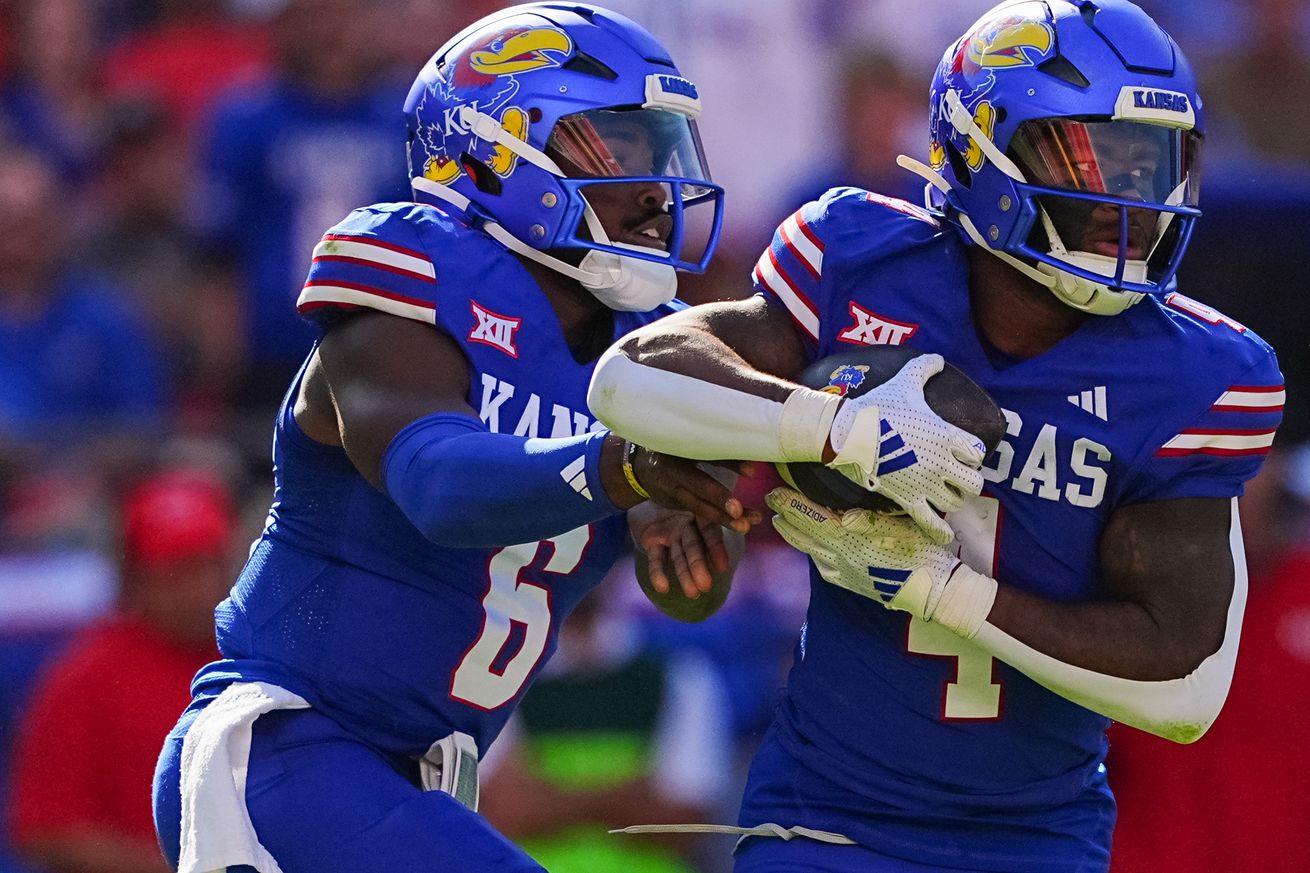 KANSAS CITY, MISSOURI - OCTOBER 19: Quarterback Jalon Daniels #6 of the Kansas Jayhawks hands off to running back Devin Neal #4 during the game against Houston Cougars during the second quarter at Arrowhead Stadium on October 19, 2024 in Kansas City, Missouri.