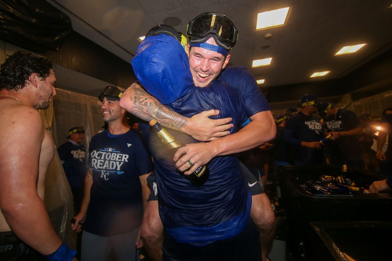 Kansas City Royals starting pitcher Cole Ragans (55) is held up by catcher Salvador Perez (13) as they celebrate after clinching a wild card playoff berth