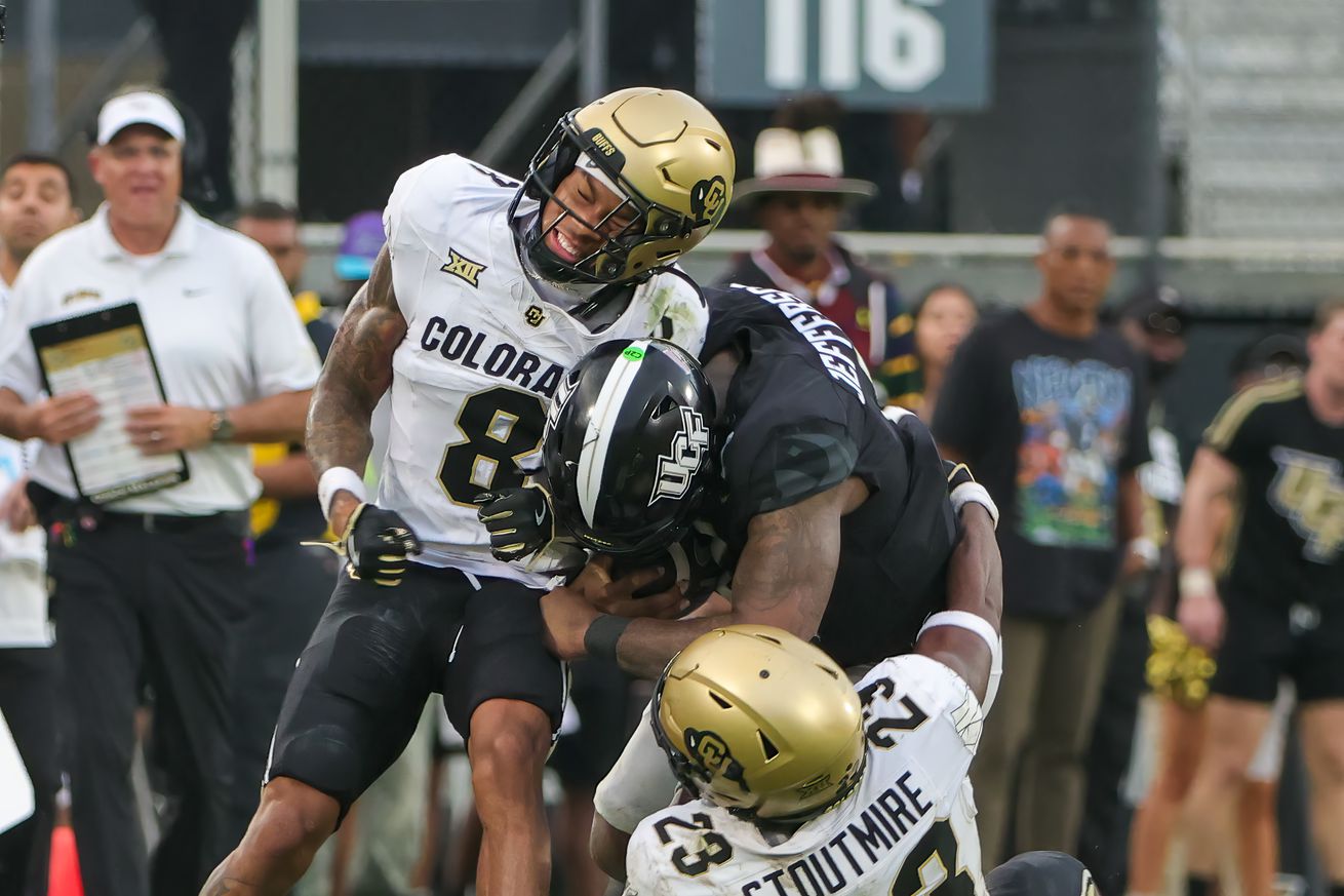 Sep 28, 2024; Orlando, Florida, USA; UCF Knights quarterback KJ Jefferson (1) is tackled by Colorado Buffaloes cornerback DJ McKinney (8) and safety Carter Stoutmire (23) during the second half at FBC Mortgage Stadium.