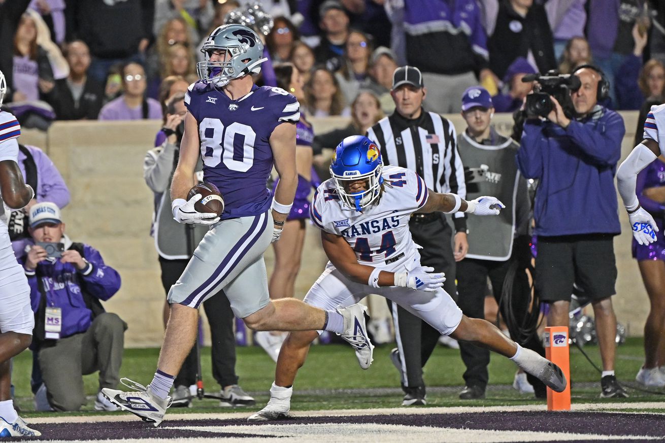 Tight end Will Anciaux #80 of the Kansas State Wildcats catches a touchdown pass against linebacker Cornell Wheeler #44 of the Kansas Jayhawks in the first half against the at Bill Snyder Family Football Stadium on October 26, 2024 in Manhattan, Kansas.