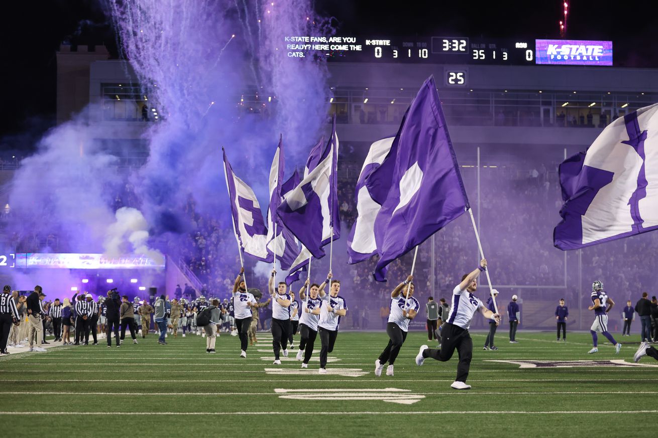 Kansas State Wildcats run onto the field with flags as smoke fills the sky before a Big 12 game between the Arizona State Sun Devils and Kansas State Wildcats on November 16, 2024 at Bill Snyder Family Stadium in Manhattan, KS.