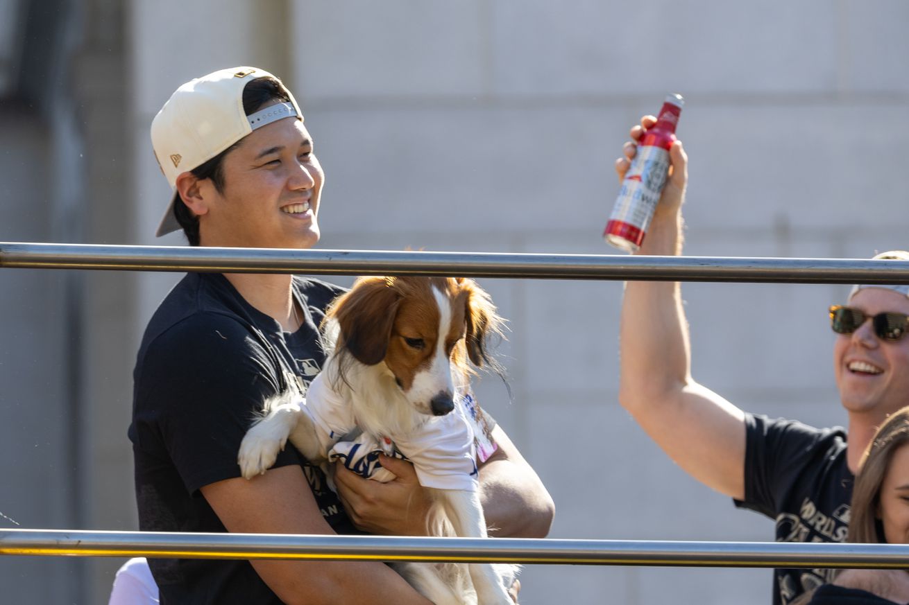 Los Angeles Dodger Shohei Ohtani hold his dog Decoy and joins players, coaches and family riding in the World Series Championship parade in front of Los Angeles City Hall.