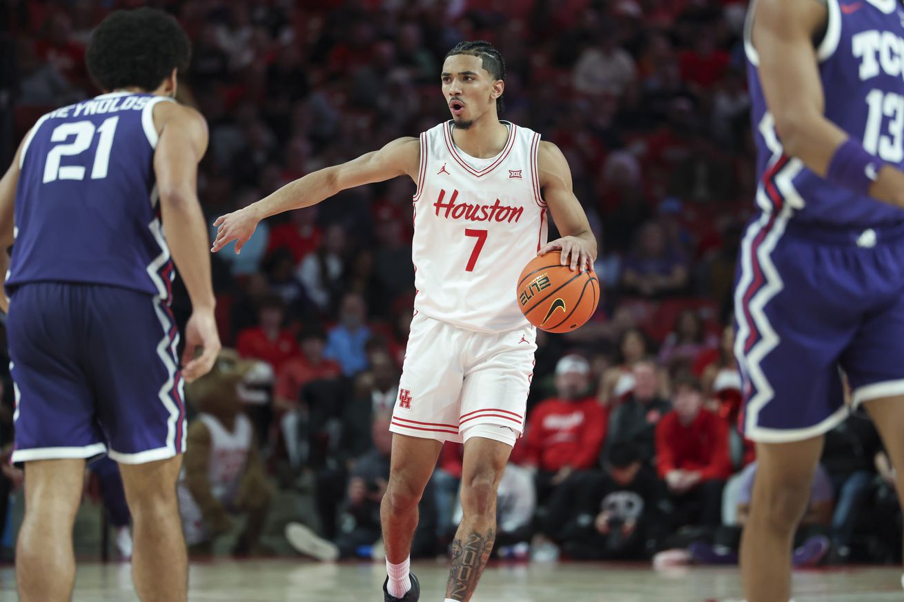 Jan 6, 2025; Houston, Texas, USA; Houston Cougars guard Milos Uzan (7) dribbles the ball as TCU Horned Frogs guard Noah Reynolds (21) defends during the second half at Fertitta Center. 