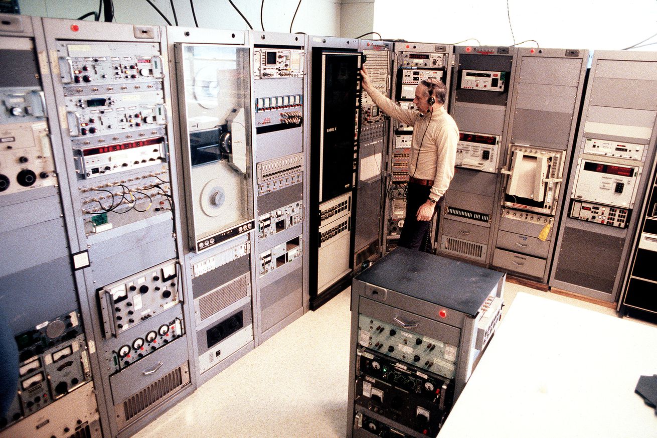 Technician works on a computer panel in the Telemetry Room, Air Force Geophysics Laboratory (AFGL).