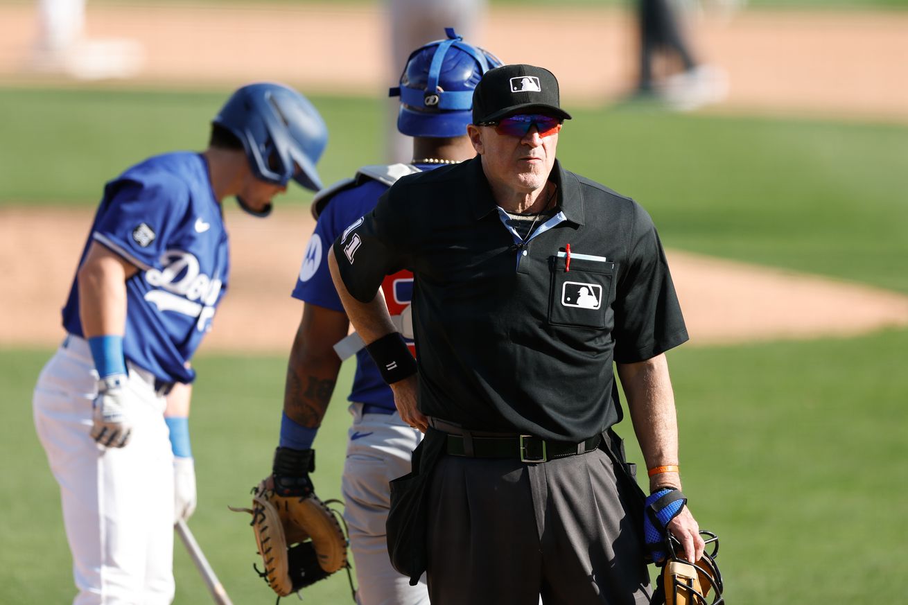 Home plate umpire Tony Randazzo #11 utilizes an automated ball-strike challenge system, or ABS, during the game between the Chicago Cubs and the Los Angeles Dodgers at Camelback Ranch on Thursday, February 20, 2025 in Glendale, Arizona